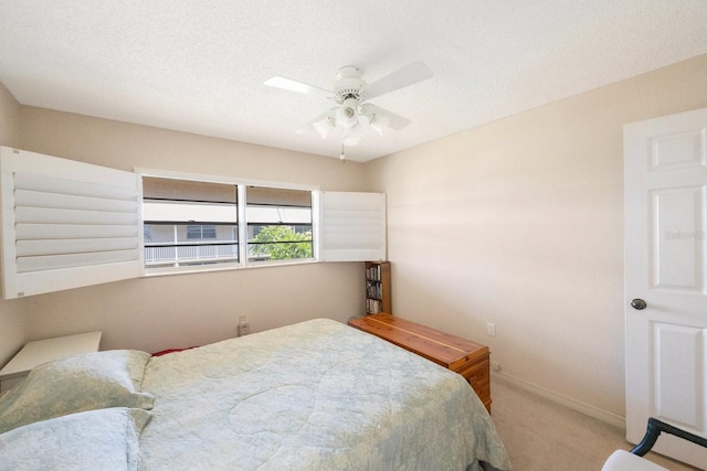 bedroom featuring a textured ceiling, carpet floors, and ceiling fan