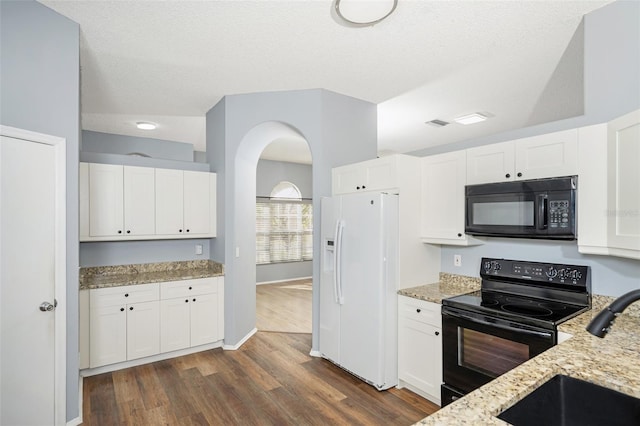 kitchen featuring light stone counters, white cabinetry, and black appliances