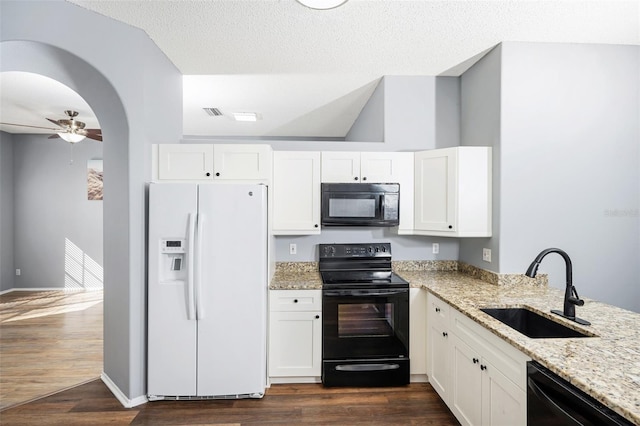 kitchen with black appliances, sink, white cabinetry, light stone countertops, and dark wood-type flooring