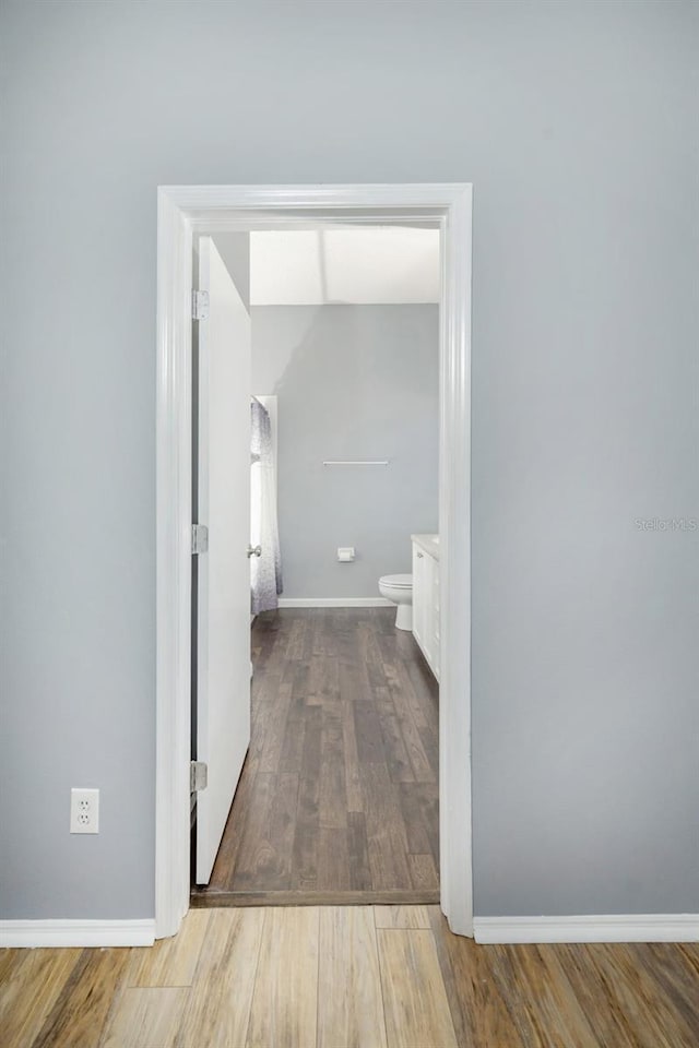 hallway with hardwood / wood-style flooring