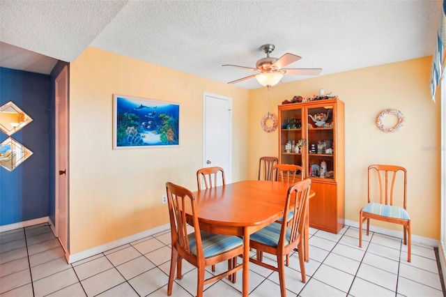 dining room with ceiling fan, light tile patterned flooring, and a textured ceiling