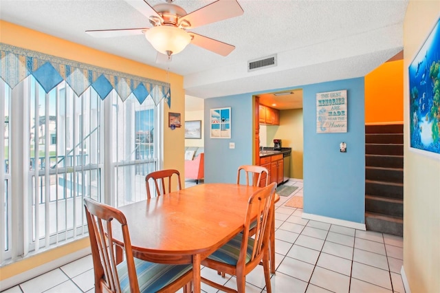 dining area with a textured ceiling, ceiling fan, and light tile patterned floors