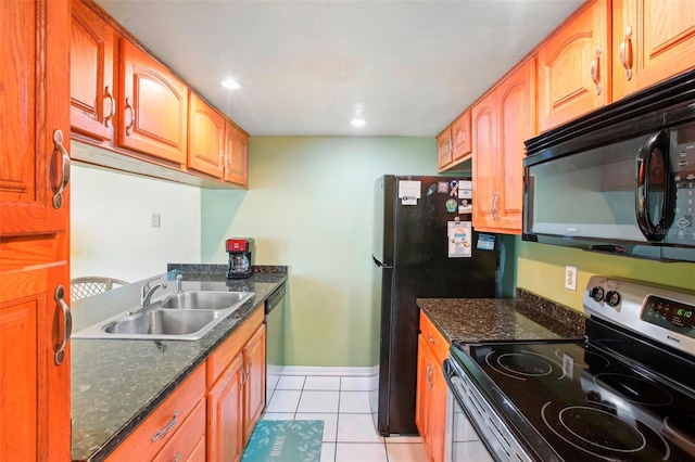 kitchen with light tile patterned flooring, stainless steel appliances, dark stone countertops, and sink