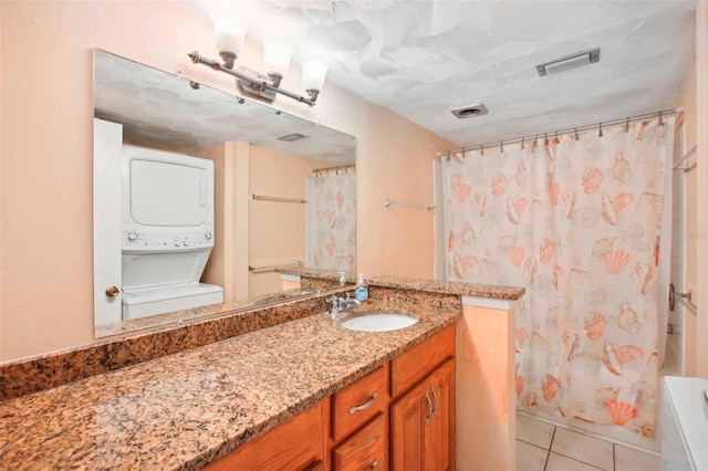 bathroom featuring tile patterned floors, stacked washer and clothes dryer, shower / tub combo with curtain, and vanity