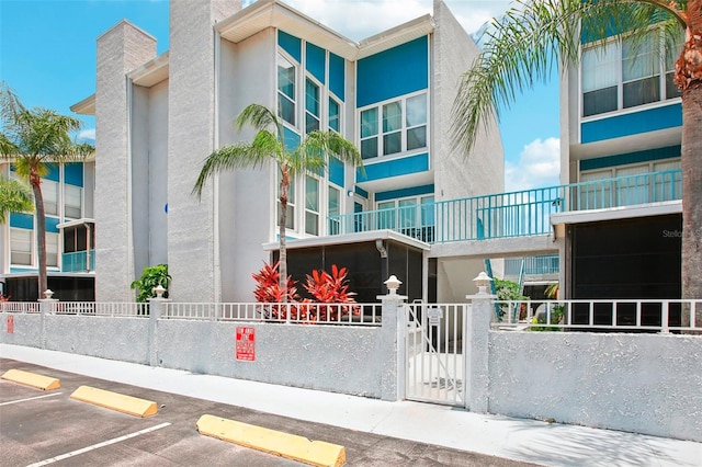 343 Rex Pl Unit F, Madeira Beach, FL 33708 - view of property featuring a fenced front yard and uncovered parking