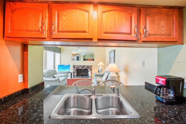 343 Rex Pl Unit F, Madeira Beach, FL 33708 - kitchen with a fireplace, dark stone counters, brown cabinets, and open floor plan