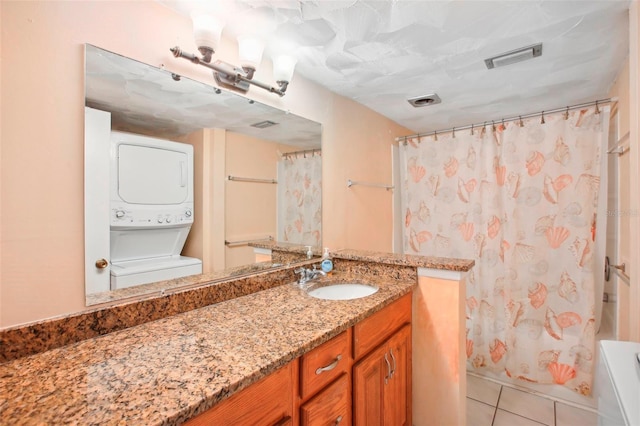 343 Rex Pl Unit F, Madeira Beach, FL 33708 - full bathroom featuring stacked washer and clothes dryer, vanity, and tile patterned flooring