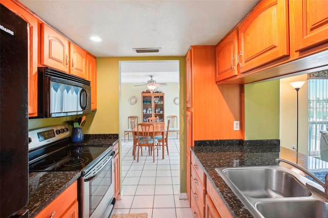 343 Rex Pl Unit F, Madeira Beach, FL 33708 - kitchen featuring black appliances, light tile patterned flooring, a ceiling fan, dark stone counters, and brown cabinets