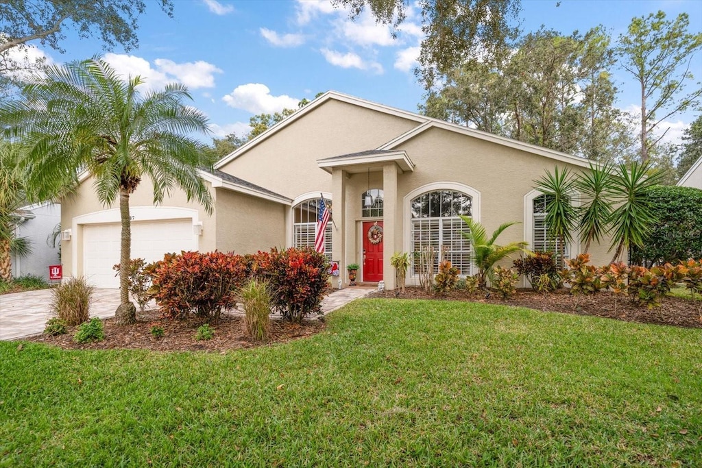 ranch-style home featuring a garage and a front yard