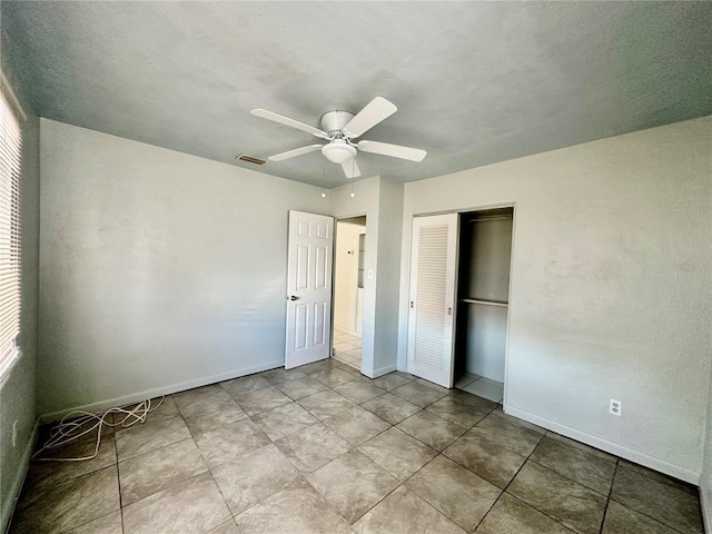 unfurnished bedroom with ceiling fan and a closet