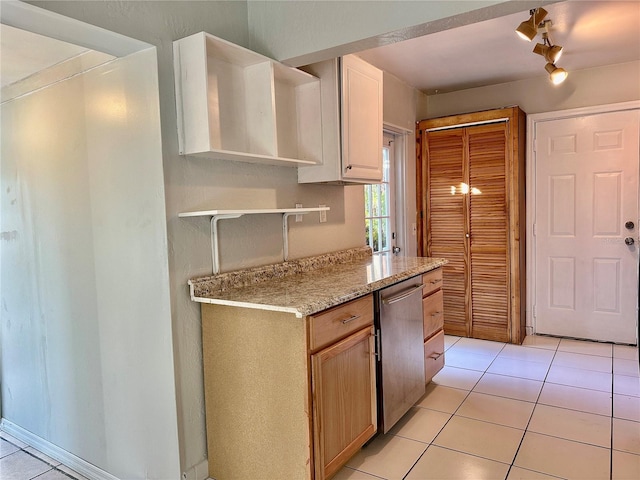 kitchen featuring light tile patterned floors, rail lighting, light brown cabinets, light stone countertops, and stainless steel dishwasher