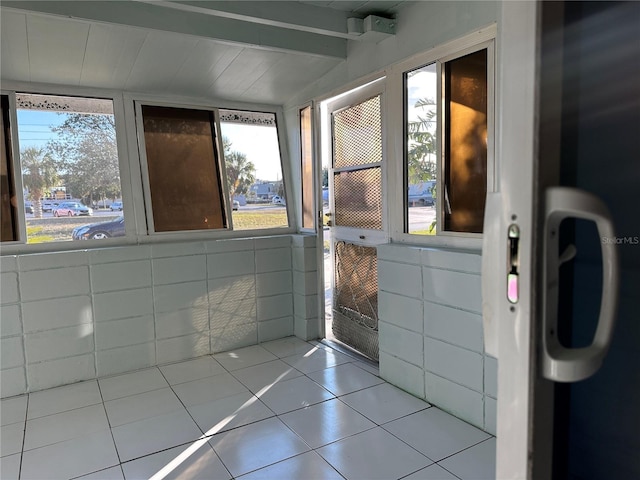 bathroom with beam ceiling and tile patterned floors