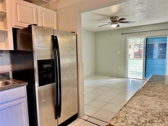 kitchen with white cabinets, stainless steel refrigerator with ice dispenser, tasteful backsplash, ceiling fan, and light tile patterned floors