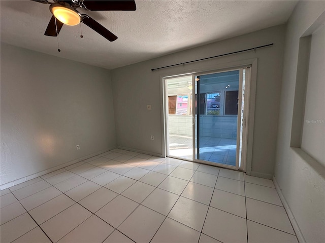 unfurnished room featuring a textured ceiling, ceiling fan, and light tile patterned floors