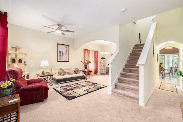 living room with ceiling fan with notable chandelier and carpet