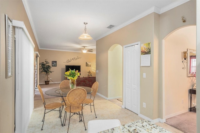 carpeted dining area with ornamental molding and ceiling fan