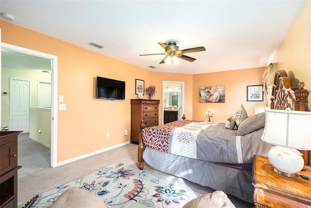 carpeted bedroom featuring ensuite bathroom and ceiling fan