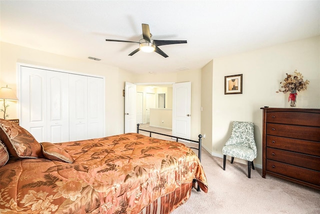 carpeted bedroom with ceiling fan and a closet