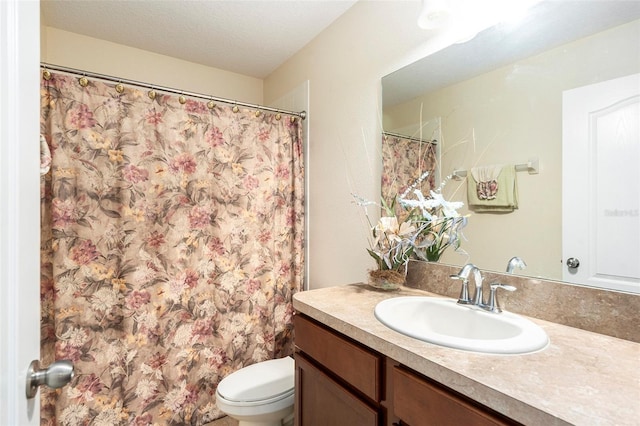 bathroom featuring toilet, vanity, and a textured ceiling