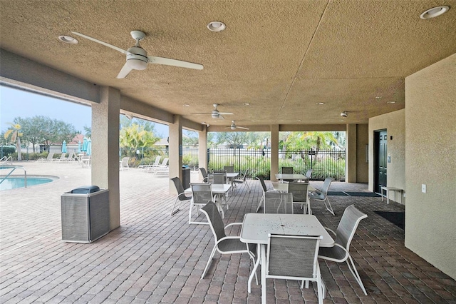 view of patio with ceiling fan and a community pool