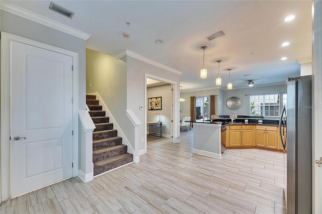 kitchen featuring kitchen peninsula, stainless steel refrigerator, crown molding, hanging light fixtures, and light brown cabinets