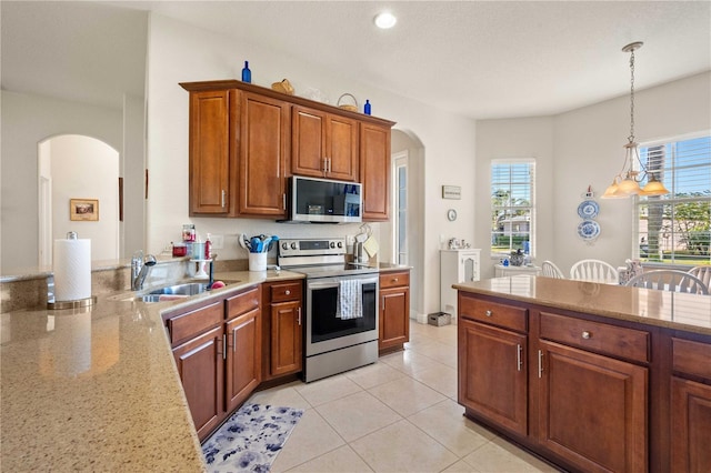 kitchen with sink, light tile patterned floors, appliances with stainless steel finishes, a notable chandelier, and decorative light fixtures