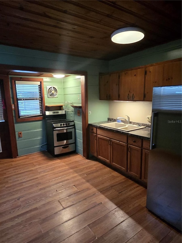 kitchen featuring dark wood-type flooring, sink, stainless steel appliances, and wooden ceiling