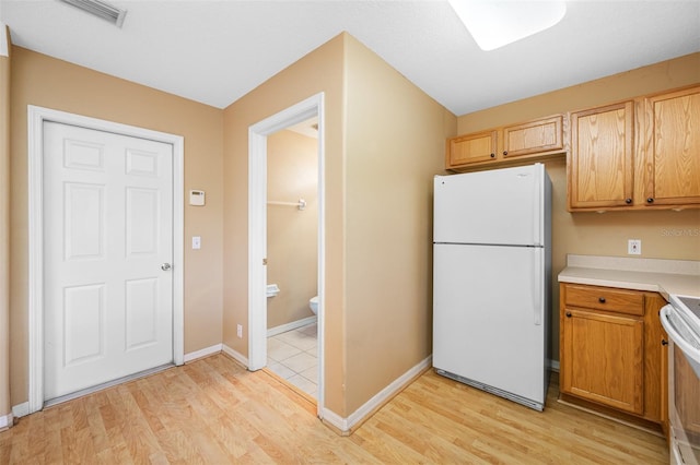 kitchen with light wood-type flooring and white appliances