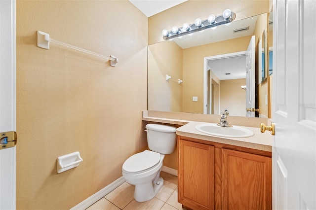 bathroom with toilet, vanity, and tile patterned flooring