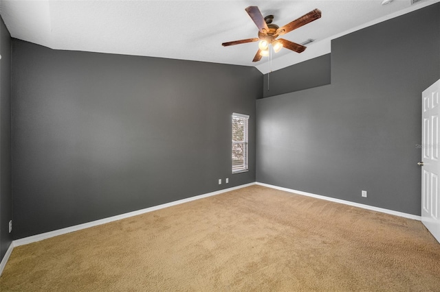 empty room featuring vaulted ceiling, ceiling fan, and carpet flooring