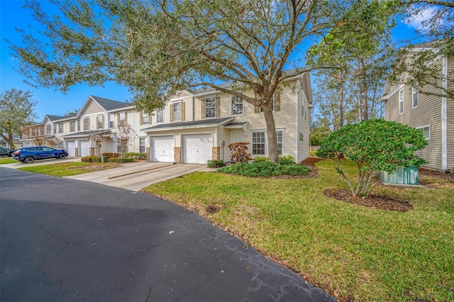 townhome / multi-family property with a front lawn and a garage