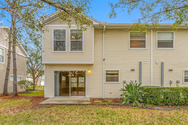 back of property featuring a patio area and a yard