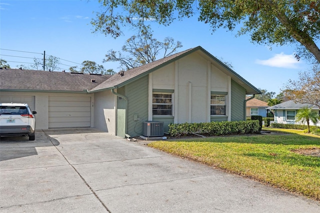 view of home's exterior featuring a garage, a yard, and central air condition unit