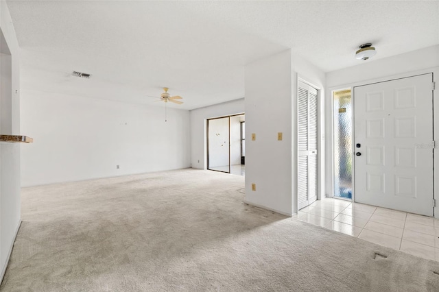 carpeted entrance foyer featuring ceiling fan