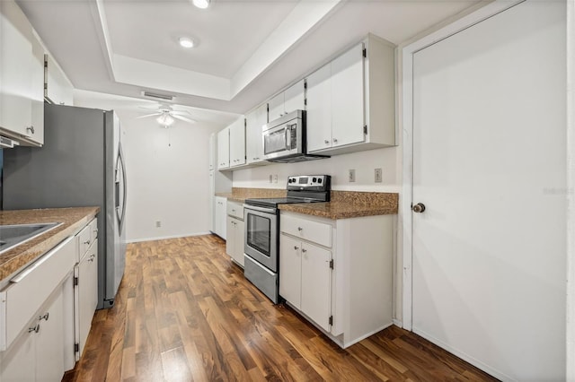 kitchen with ceiling fan, white cabinets, appliances with stainless steel finishes, and dark hardwood / wood-style flooring