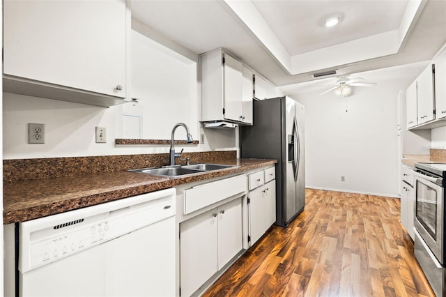 kitchen with ceiling fan, sink, hardwood / wood-style flooring, appliances with stainless steel finishes, and white cabinets