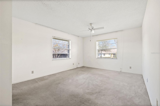 carpeted empty room featuring ceiling fan and a textured ceiling