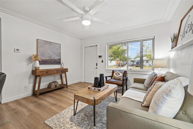 living room with light wood-type flooring, ceiling fan, and ornamental molding