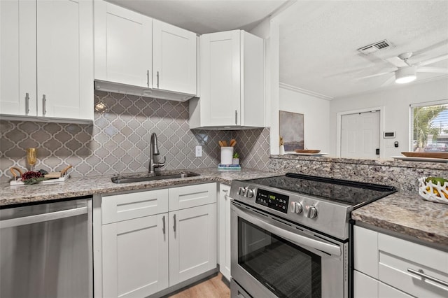 kitchen featuring decorative backsplash, sink, white cabinetry, light stone countertops, and stainless steel appliances