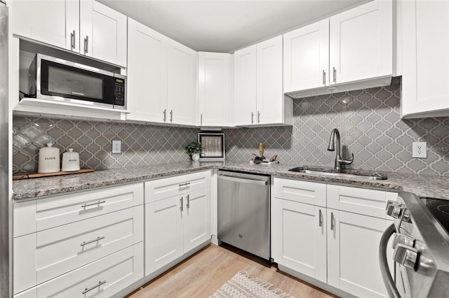 kitchen featuring sink, white cabinetry, stainless steel appliances, and tasteful backsplash