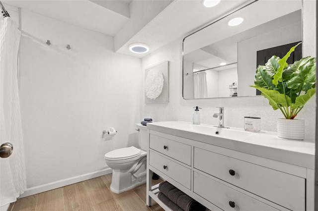 bathroom with toilet, a shower with curtain, hardwood / wood-style flooring, and vanity