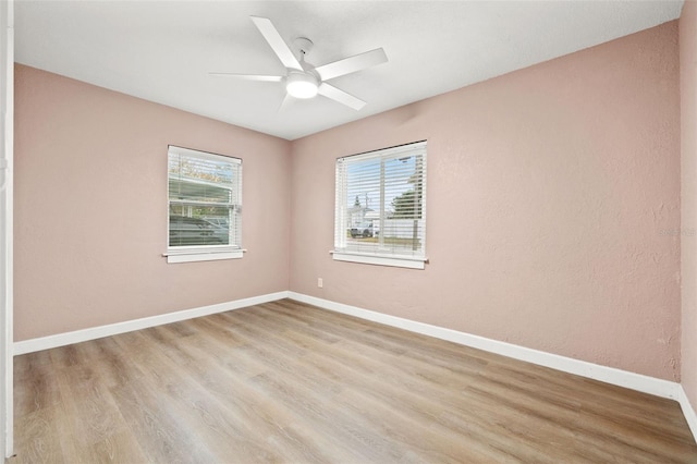 unfurnished room featuring ceiling fan, light hardwood / wood-style flooring, and a healthy amount of sunlight