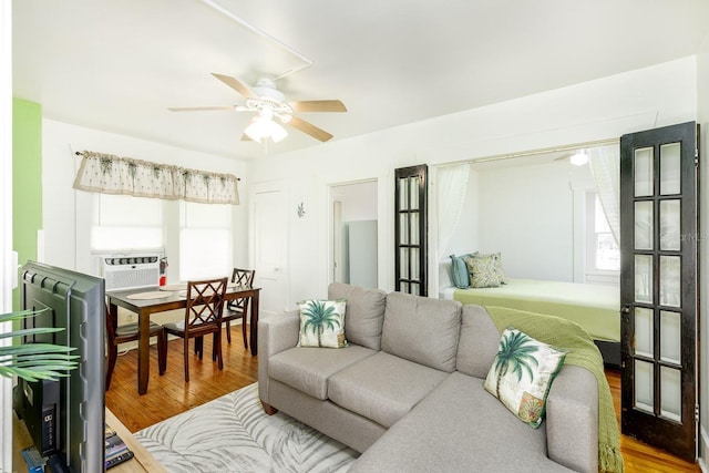 living room with wood-type flooring, ceiling fan, and cooling unit