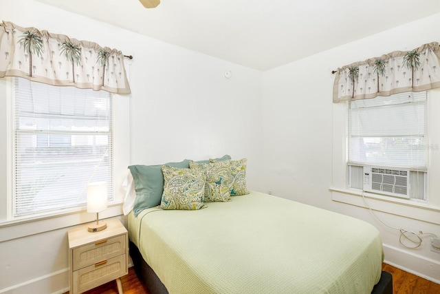 bedroom featuring cooling unit and dark hardwood / wood-style flooring