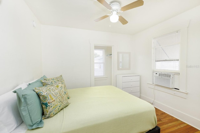 bedroom featuring wood-type flooring, ceiling fan, and cooling unit