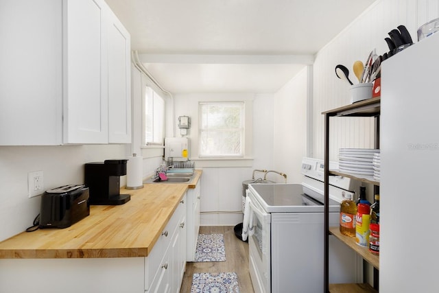 clothes washing area featuring sink, washer / clothes dryer, and light hardwood / wood-style flooring