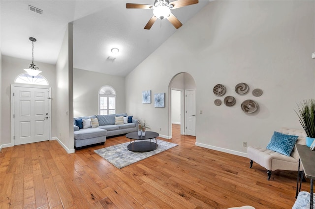 living room featuring ceiling fan, light hardwood / wood-style flooring, and high vaulted ceiling