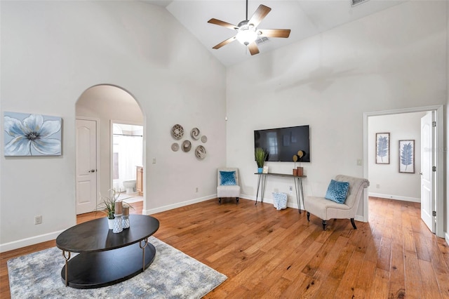 sitting room with high vaulted ceiling, wood-type flooring, and ceiling fan