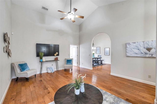 living room featuring ceiling fan, hardwood / wood-style floors, and high vaulted ceiling