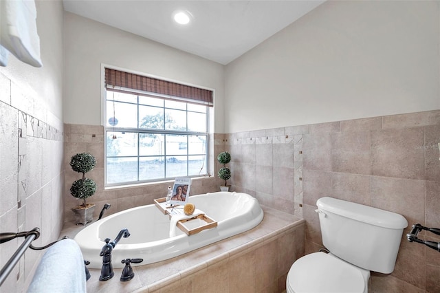 bathroom featuring toilet, tile walls, and a relaxing tiled tub